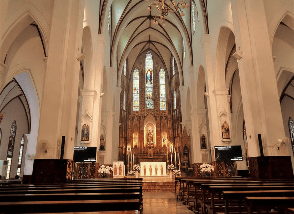Inside the cathedral, warm light filters through stained glass, filling the space with quiet beauty